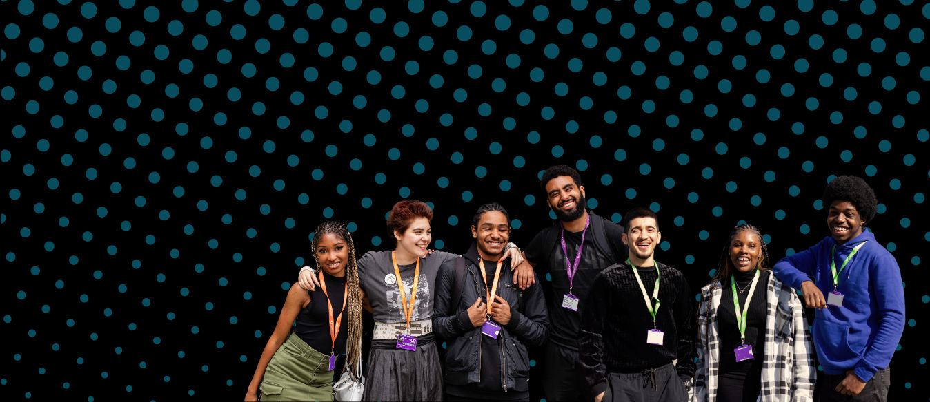 Group of six South Bank Colleges students smiling wearing the college's lanyards standing against a polka dot background. They appear cheerful and are dressed casually.